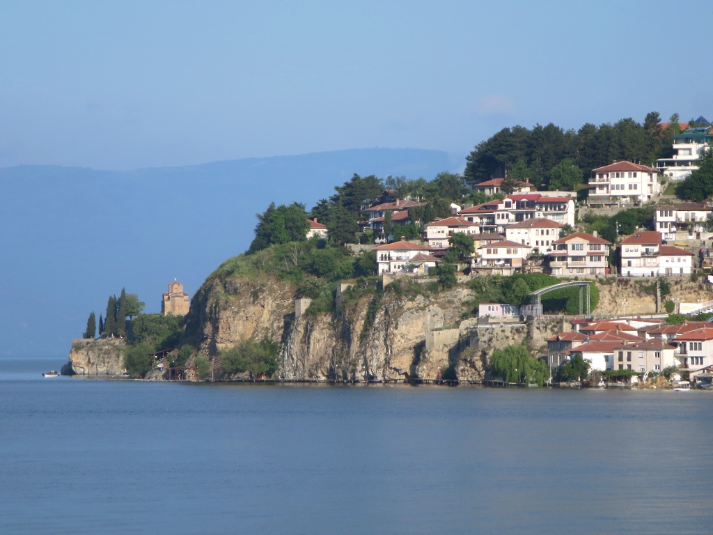 Red-roofed houses of Ohrid old town rising above Lake Ohrid on a sunny day