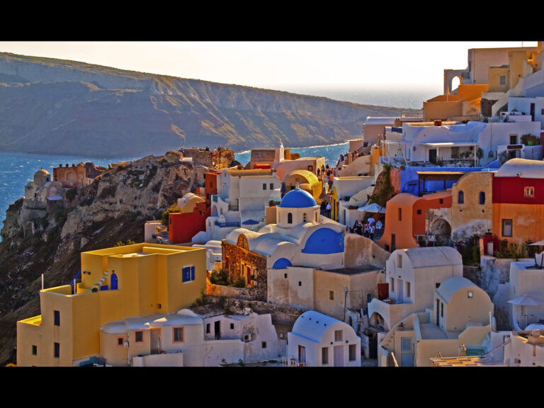 Colorful houses and whitewashed homes stacked on the cliffs of Oia, Santorini, Greece