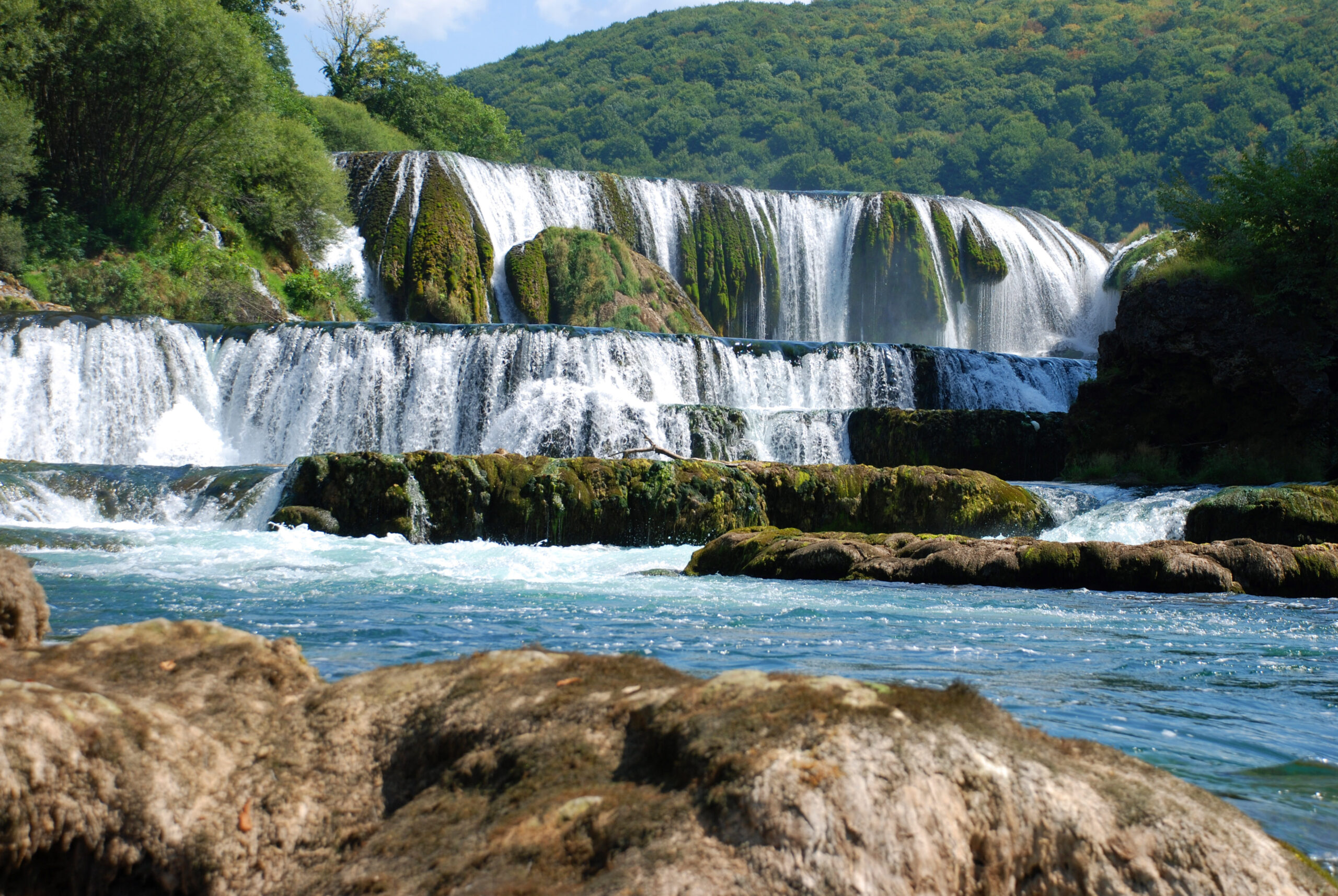 The wide Strbacki Buk waterfall dropping over travertine in Una National Park