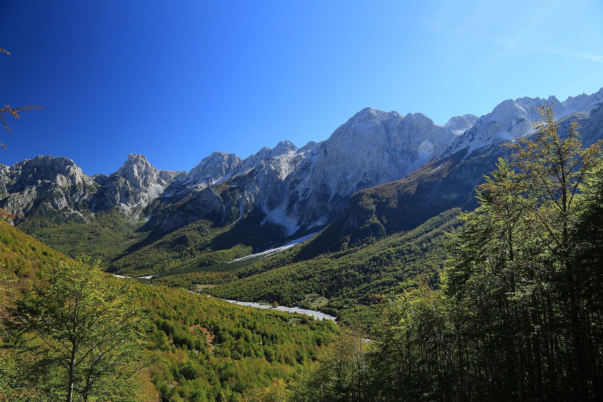 Jagged peaks of the Albanian Alps above the green Theth valley in hiking season