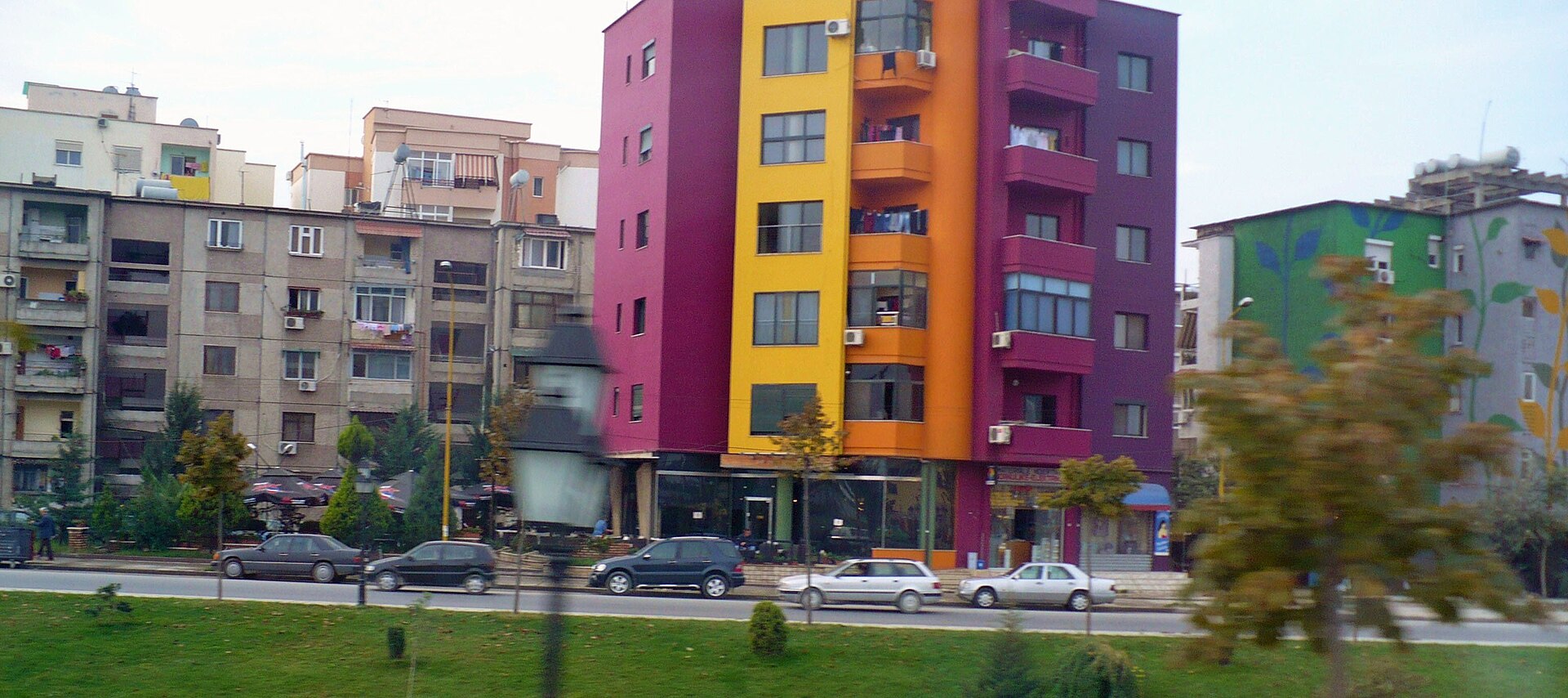 Brightly painted apartment blocks on a Tirana street, the signature look of the city