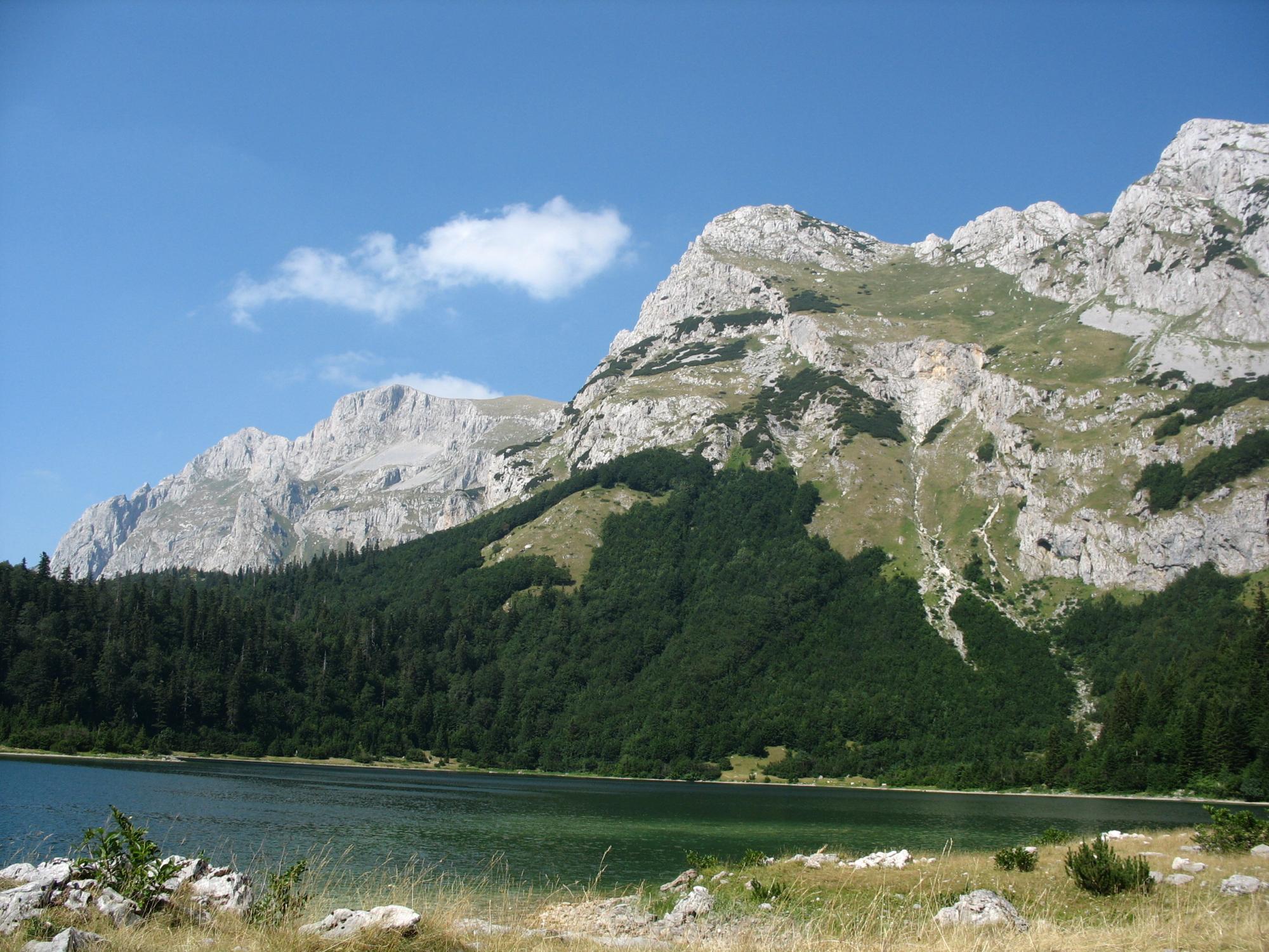 The heart shaped Trnovacko lake beneath the limestone walls of Maglic