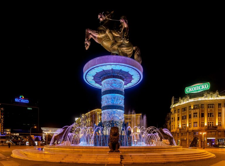 The Warrior on a Horse statue and fountain glowing at night in Macedonia Square, Skopje